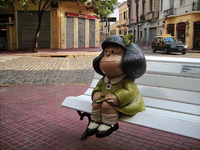 Mafalda statue sitting on a white bench in Buenos Aires.