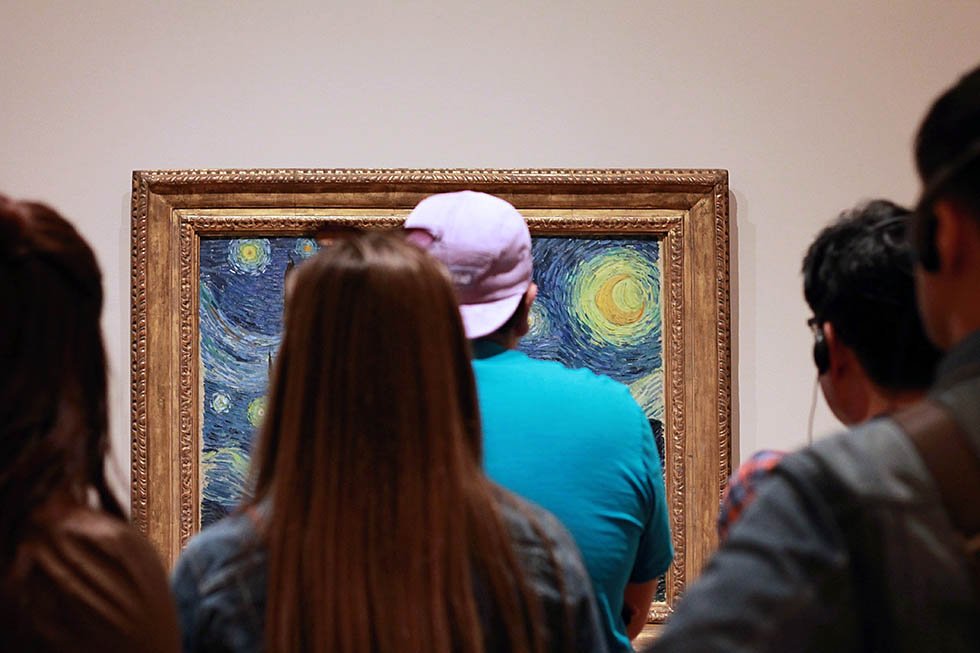 Group of people starring at Van Gogh's Starry Night painting in the Van Gogh Museum.