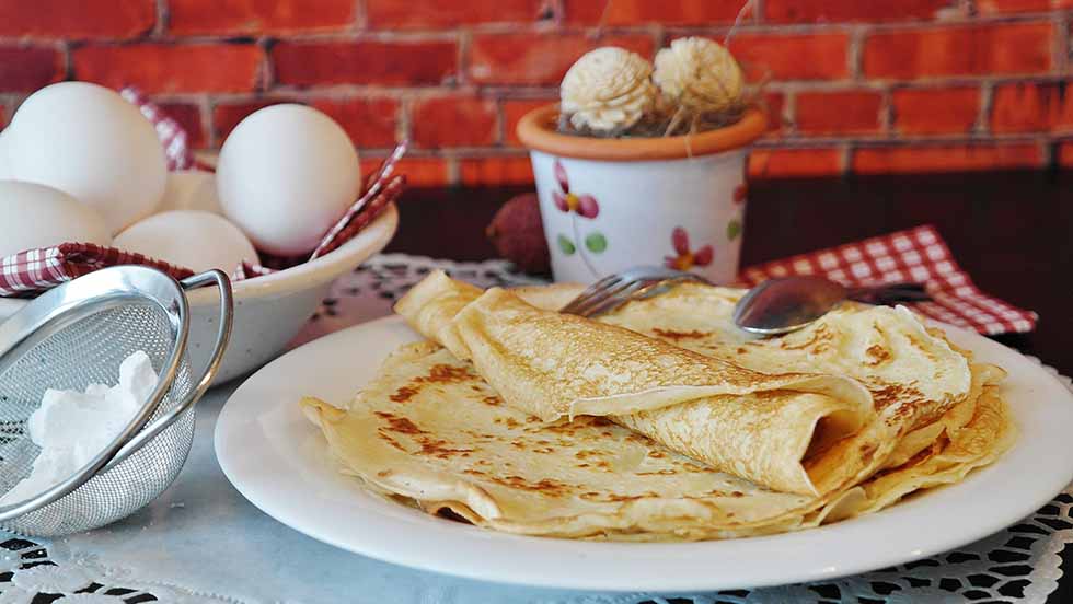 Typical Dutch food, a thin pancake on a white plate.