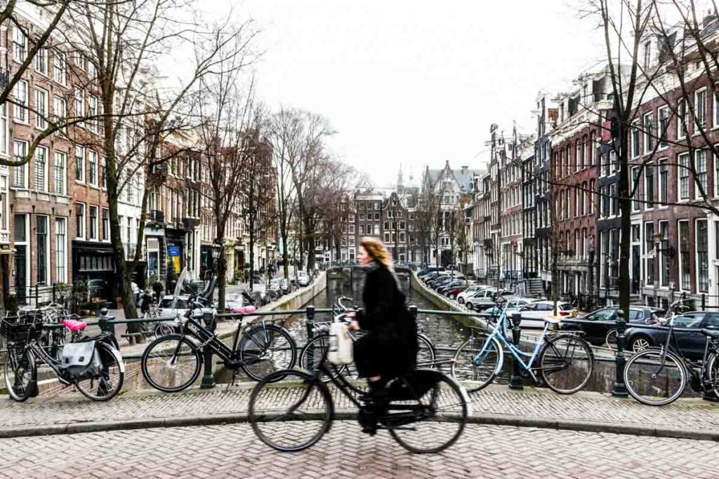 Woman cycling over a bridge in Amsterdam