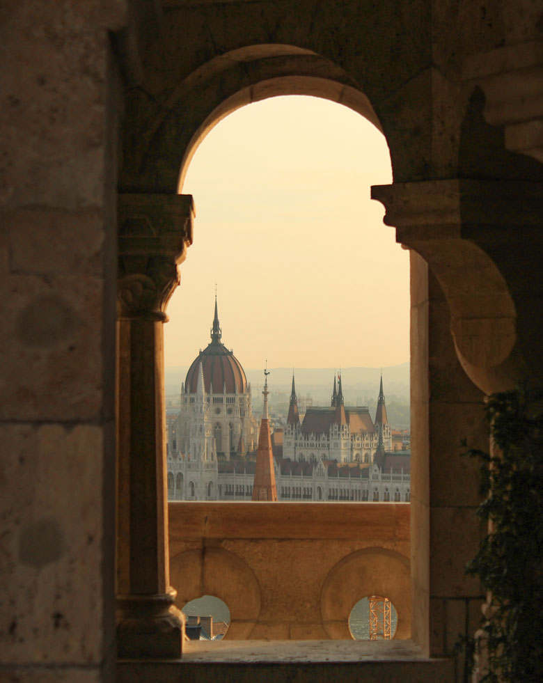 Hungarian parliament building seen from between columns in Budapest