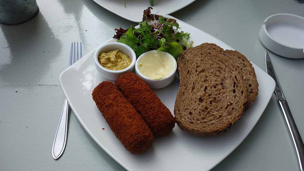 Dutch kroket with bread on a white board