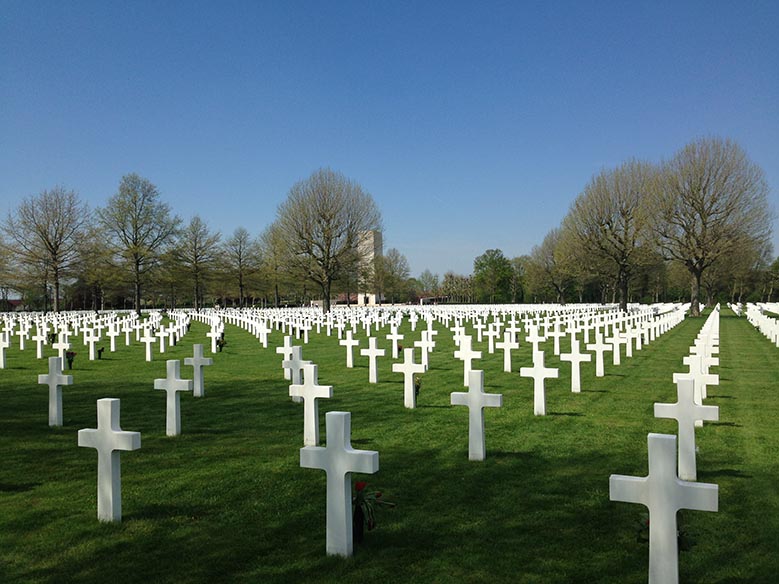 White crosses standing on the green grass in the Margraten American Cemitery near Maastricht.