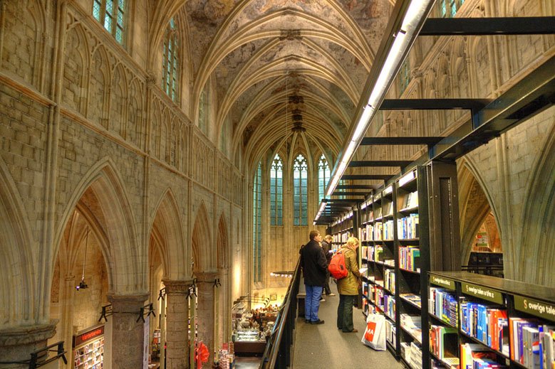 Two people reading inside a bookstore in a church in Maastricht.