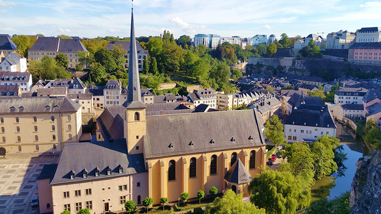 Yellow church and buildings in Luxembourg city seen from above.