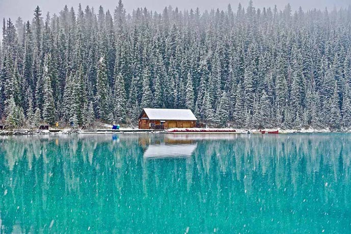 Snowing on a blue lake in Banff Canada