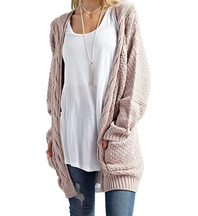 Woman wearing light pink cardigan for winter in Europe.