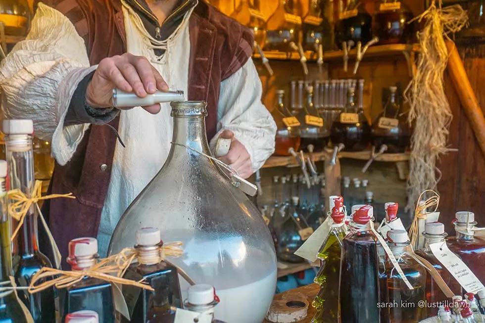 Man preparing white drink in traditional clothes in a Christmas market in Munich