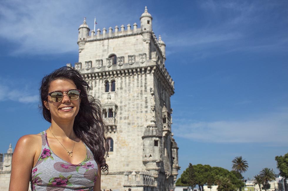 Brunette smiling at the camera in front of Belem Tower in Lisbon #Portugal #Europe #Travel