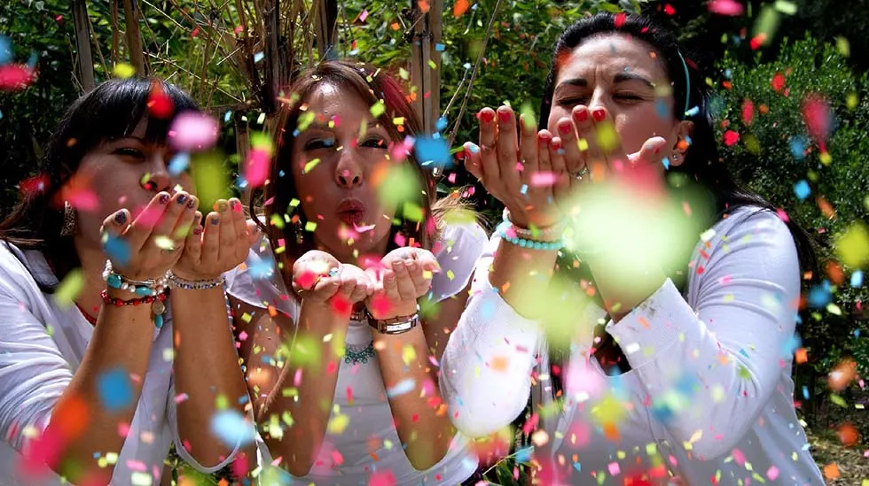 Woman blowing colorful little papers in the air