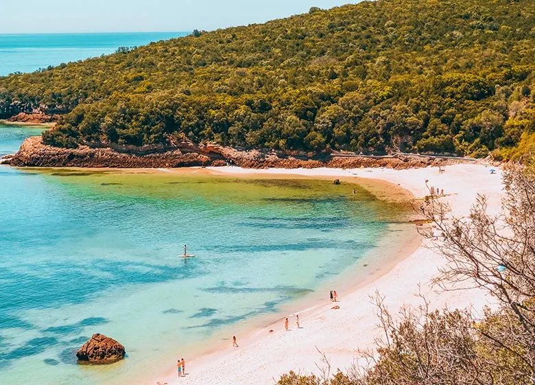 Blue sea water and white sand at Galapos beach near Arrábica natural park in Setúbal near Lisbon, Portugal