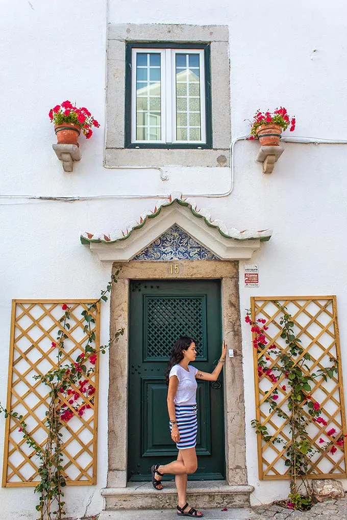 Woman standing in front of a green door staring away from the camera