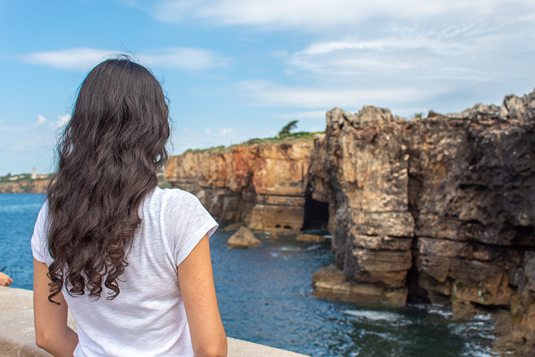 Brunette staring at the cliffs in Cascais, Portugal