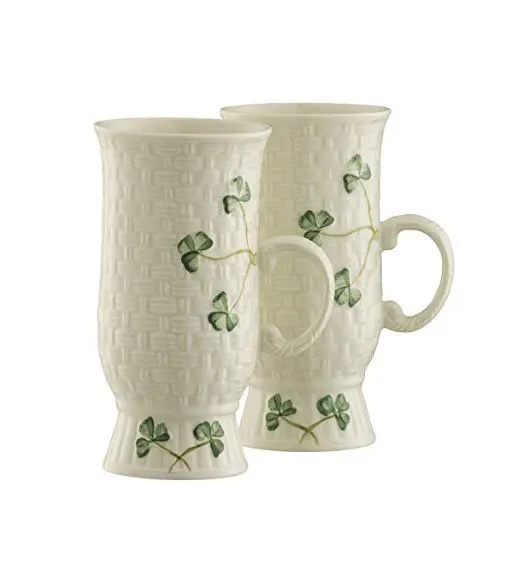 Two white belleek mugs decorated with green shamrocks