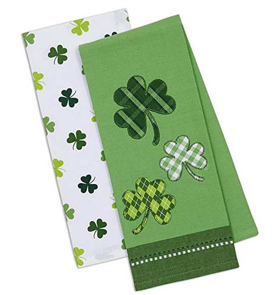 Folded white dish towel with green shamrocks and green dish towel