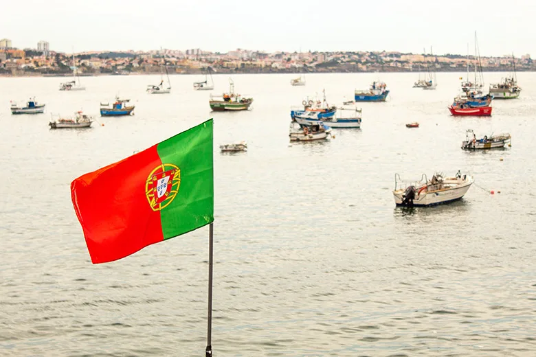 Portuguese flag near the water full with small boats in Cascais