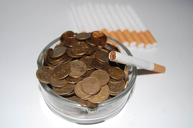 Ashtray filled with coins and a cigarrete