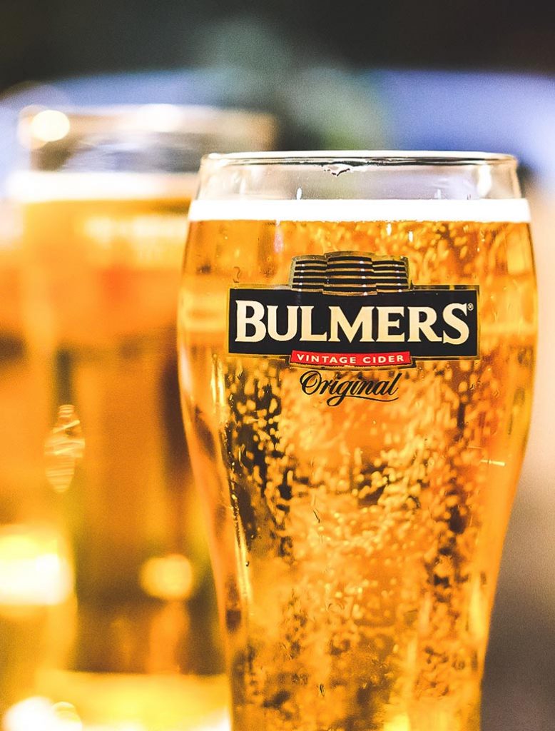 Yellow bubbly drink in a glass of Bulmers cider