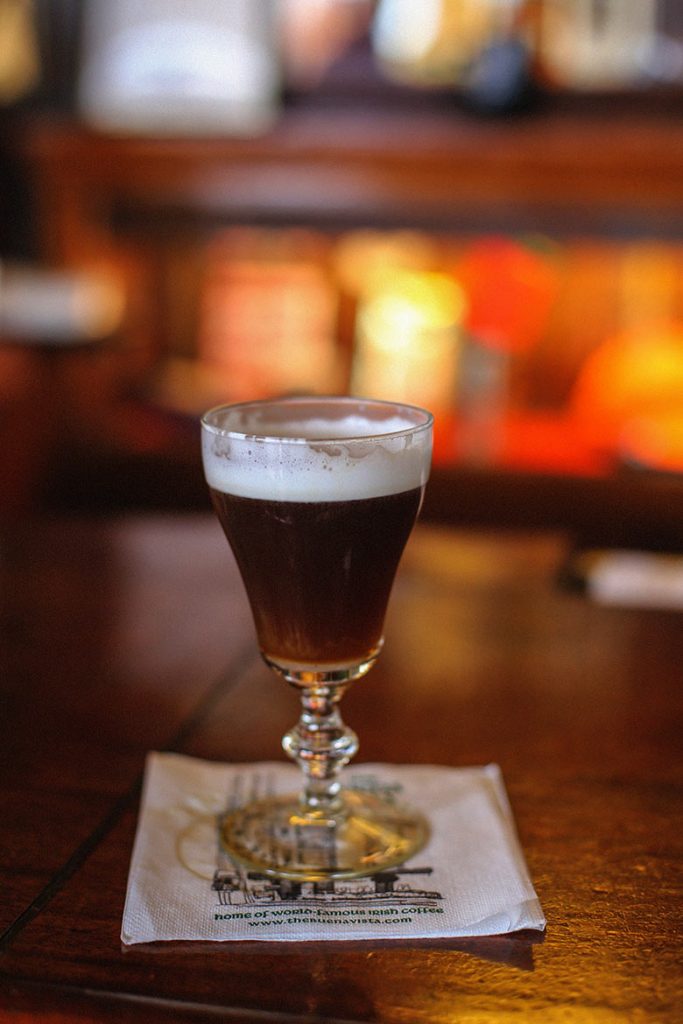 A dark drink with white foam in a glass, is the famous Irish coffee