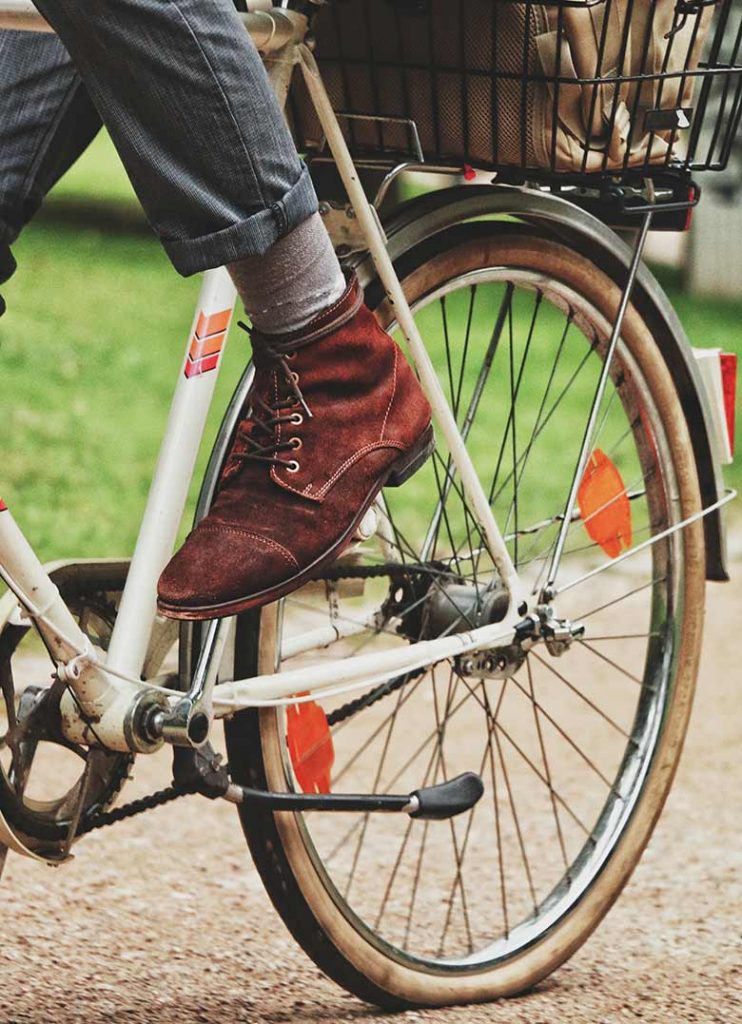 Foot of a man cycling to save money for travel