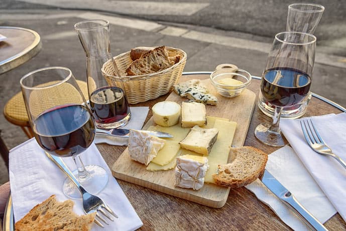 Glass of wine and cheese on a wooden table in Paris