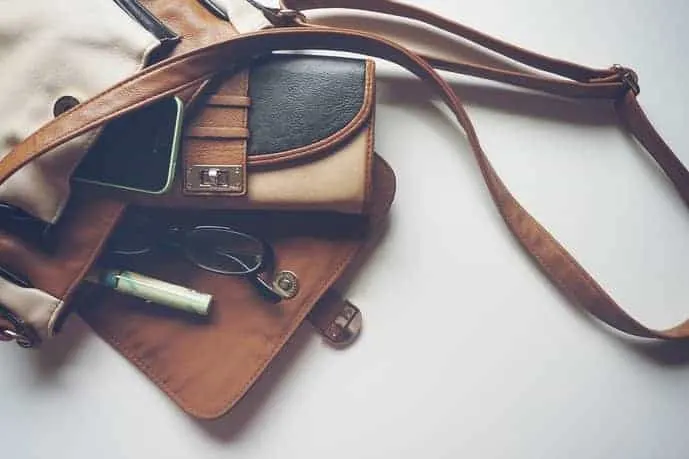 Open travel purse with items rolling out
