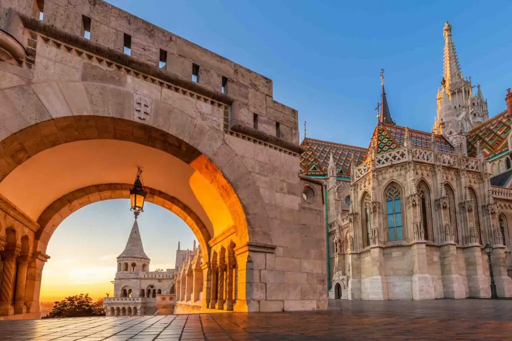 North gate of the Fisherman's Bastion (Halaszbastya) with the beautiful Matthias Church at golden sunrise, Budapest, Hungary