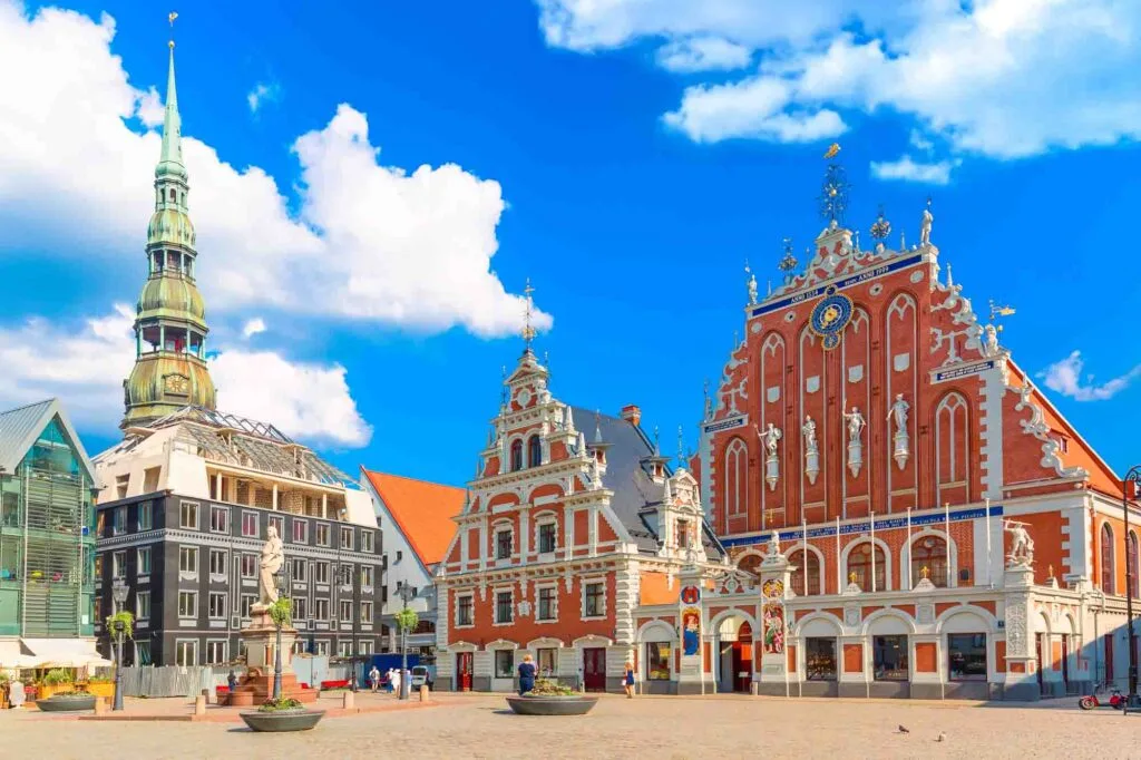 View of the Old Town Ratslaukums square, Roland Statue, The Blackheads House and St Peters Cathedral against blue sky in Riga, Latvia