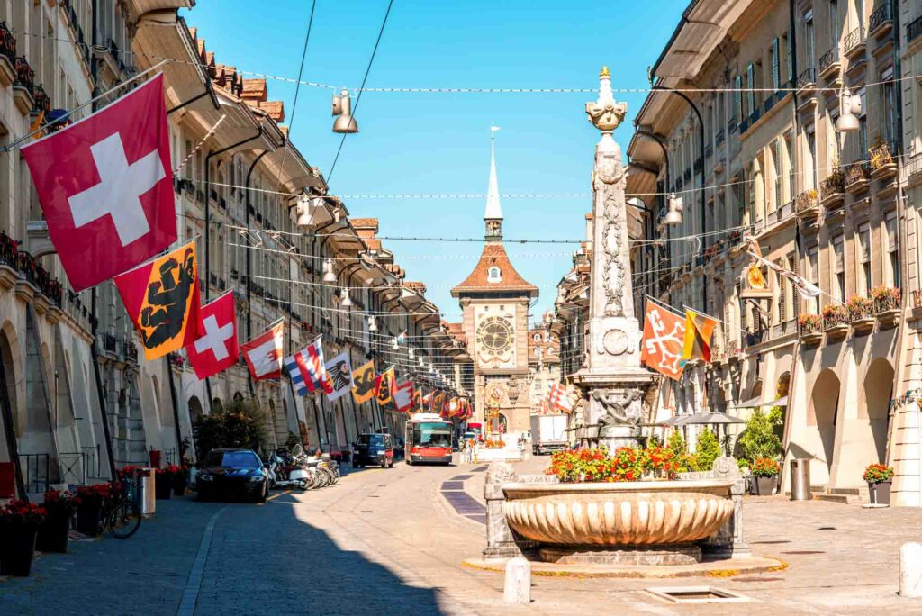 Street view on Kramgasse with fountain and clock tower in the old town of Bern, Switzerland