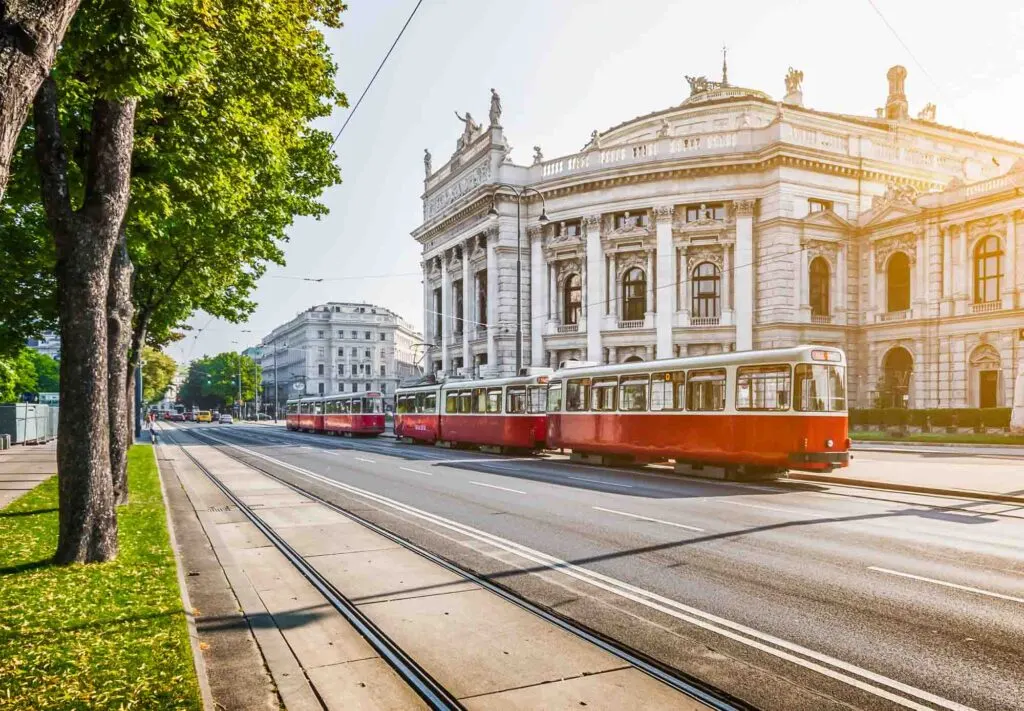 Burgtheater (Imperial Court Theatre) and traditional red electric tram at sunrise in Vienna, Austria